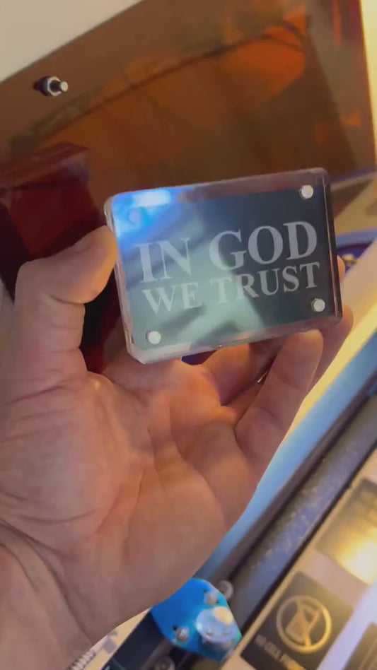 Hand holding metal laser engraved keepsake card, with In God We Trust patriotic religious text - shown inside an optional Acrylic Display Case