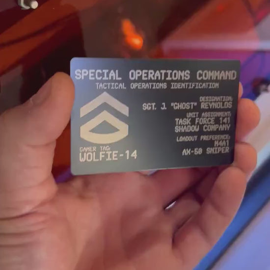 Hands rotating personalized metal business card to display engraved personalized FPS gaming text