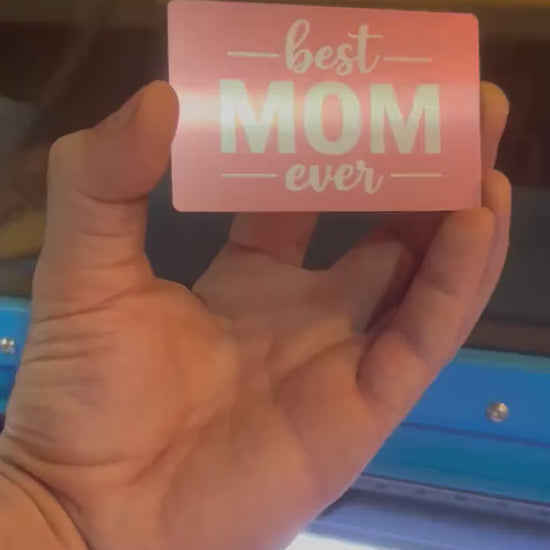 Hand holding a laser engraved rose gold/silver metal best mom ever mother's day keepsake gift card