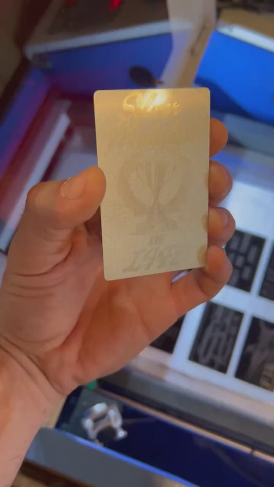 Video of engraved metal wallet card turning under light to show reflective finish