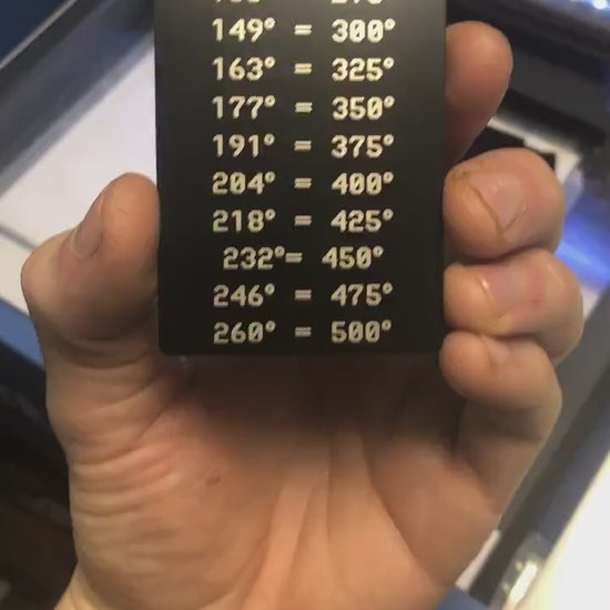 Hand holding a metal laser engraved baking conversion temperature chart with a set of Celsius and Fahrenheit temperatures