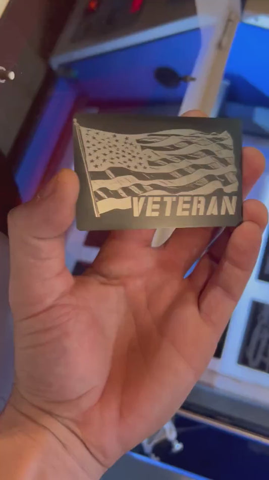 Video of engraved metal veteran wallet card turning under light to show reflective finish