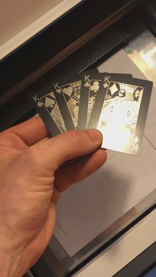 Close up video of hand holding 4 laser engraved metal poker gift cards with King of Spades, King of Hearts, King of Clubs and King of Diamonds cards