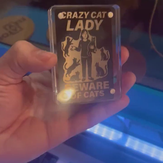 Showcasing a metal black/silver metal pet lovers gift card that reads "CRAZY CAT LADY" Beware of Cats - with silly kitten graphics