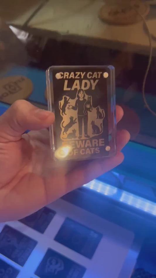 Showcasing a metal black/silver metal pet lovers gift card that reads "CRAZY CAT LADY" Beware of Cats - with silly kitten graphics