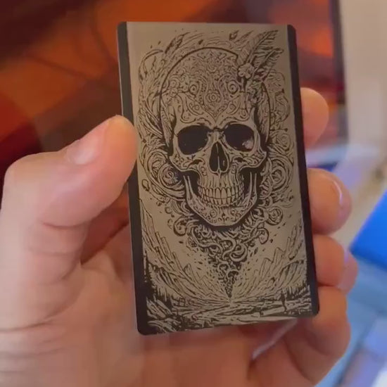 Hand holding a laser engraved illustration graphic card with surreal skull engraving art
