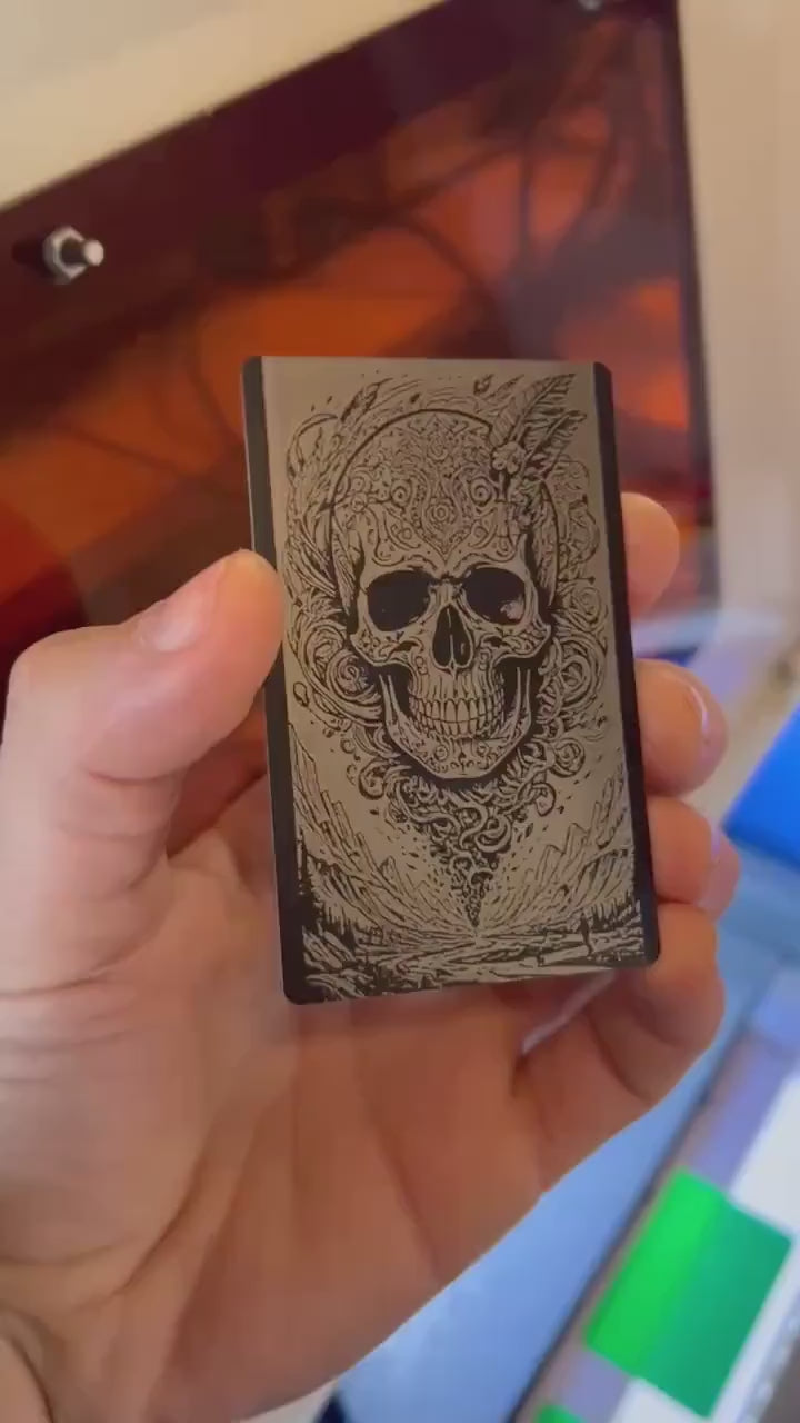 Hand holding a laser engraved illustration graphic card with surreal skull engraving art