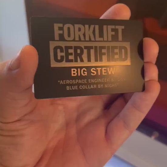 Close up video of hand holding a laser engraved metal gift card with Forklift Certified text, and personalized customer name and message engraved below