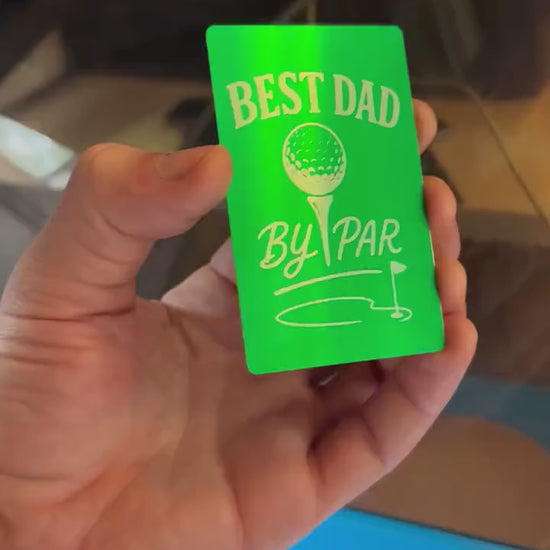 Close-up video of laser engraved green/silver Best Dad By Par metal gift card rotating to show shine and detail