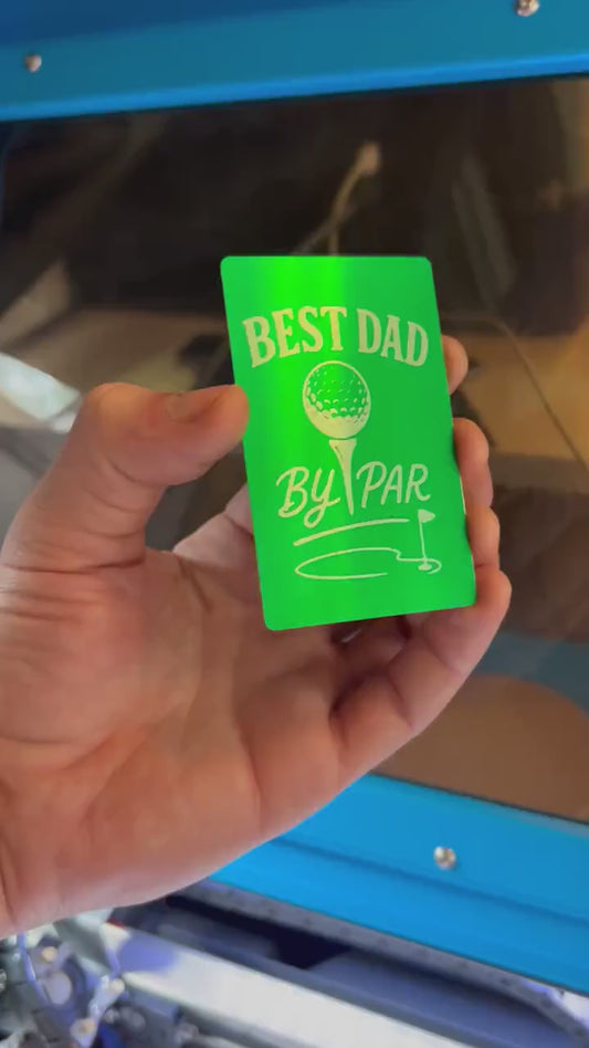 Close-up video of laser engraved green/silver Best Dad By Par metal gift card rotating to show shine and detail