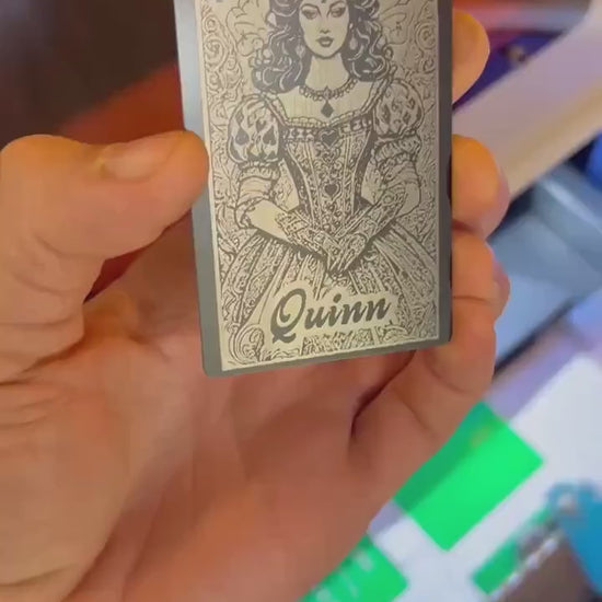 Hand holding a laser engraved personalized gift card with custom name engraved reading "Quinn", on top of our Lady Luck Ace of Spades poker illustration anodized aluminum gift card