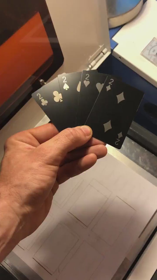 Custom anodized aluminum 2 of clubs, spades, heart snd diamonds playing card being rotated to highlight engraving design