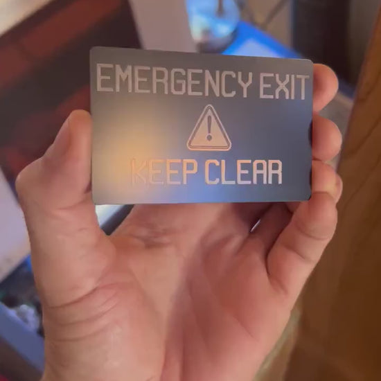 Close-up video of laser engraved metal card rotating to show shine and detail on Emergency Exit placard