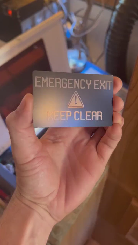 Close-up video of laser engraved metal card rotating to show shine and detail on Emergency Exit placard