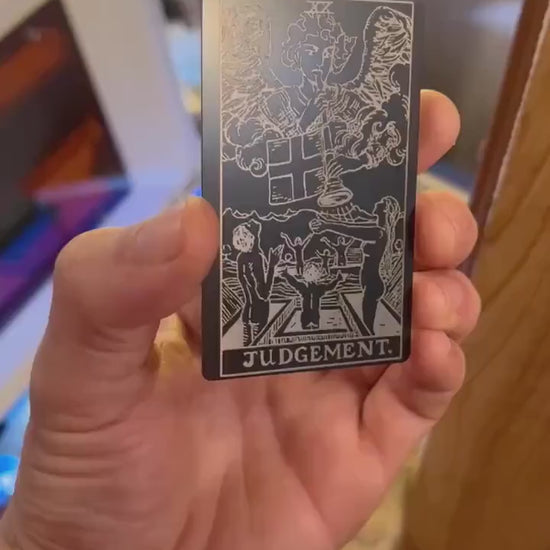 Custom anodized aluminum matte black and silver Judgement tarot card being rotated to highlight line design engraving