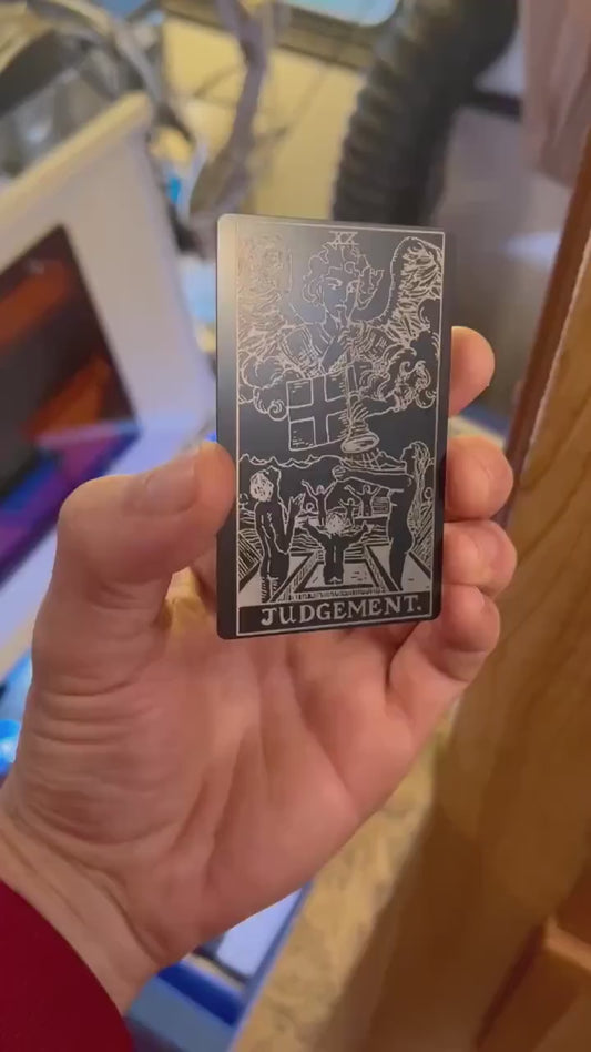 Custom anodized aluminum matte black and silver Judgement tarot card being rotated to highlight line design engraving