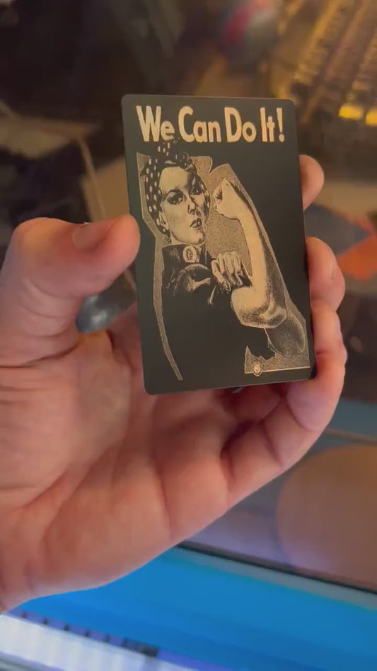 Video of engraved metal We Can Do it wallet card turning under light to show reflective finish