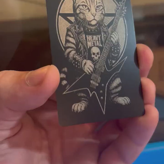 Hand holding a laser engraved novelty musician metal wallet insert gift, with heavy metal kitten rocker illustration artwork