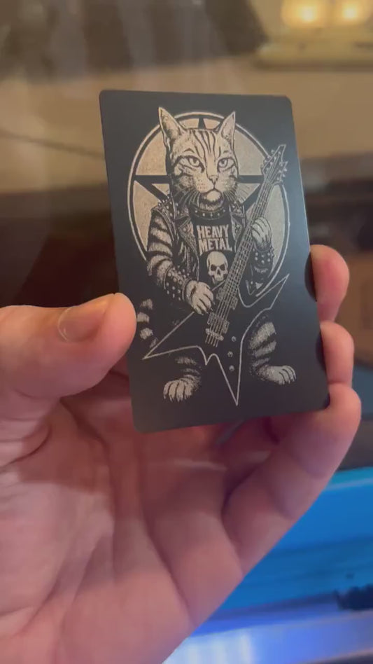 Hand holding a laser engraved novelty musician metal wallet insert gift, with heavy metal kitten rocker illustration artwork