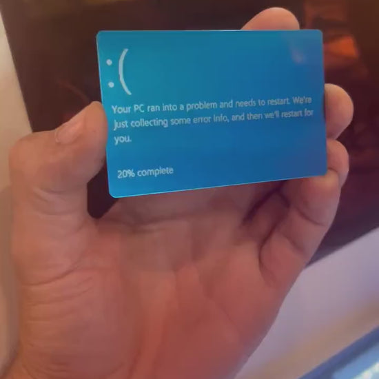 Hand holding a laser engraved blue/silver laser engraved anodized aluminum IT funny gag gift blue screen of death text card