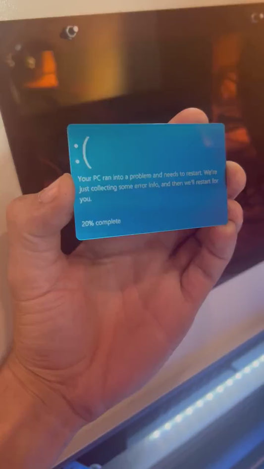 Hand holding a laser engraved blue/silver laser engraved anodized aluminum IT funny gag gift blue screen of death text card