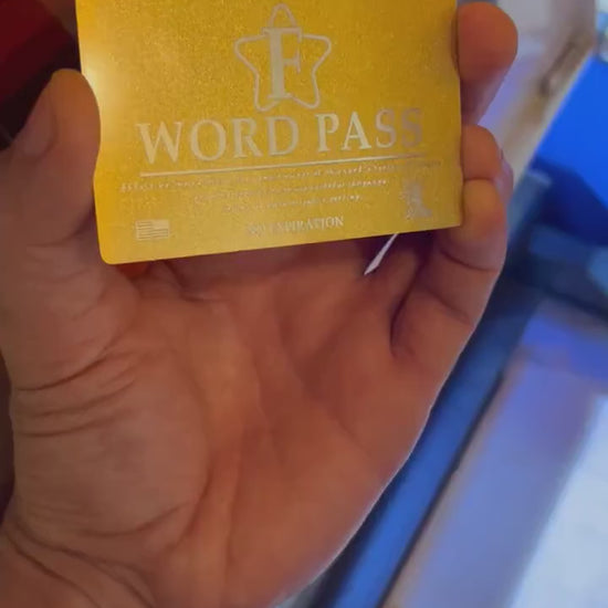 Laser engraved metal business card, with F word Pass text in front of a laser engraving machine