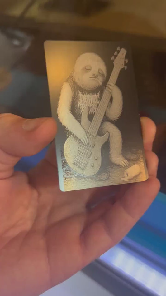 Laser engraved metal novelty gift card for musicians, with a rocker Sloth bassist on a stage with spilled beer can and cigarette