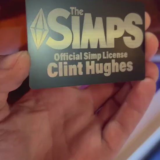 Video of hand holding a metal laser engraved gag gift with The Simps, Official Simp License and custom name engraving 