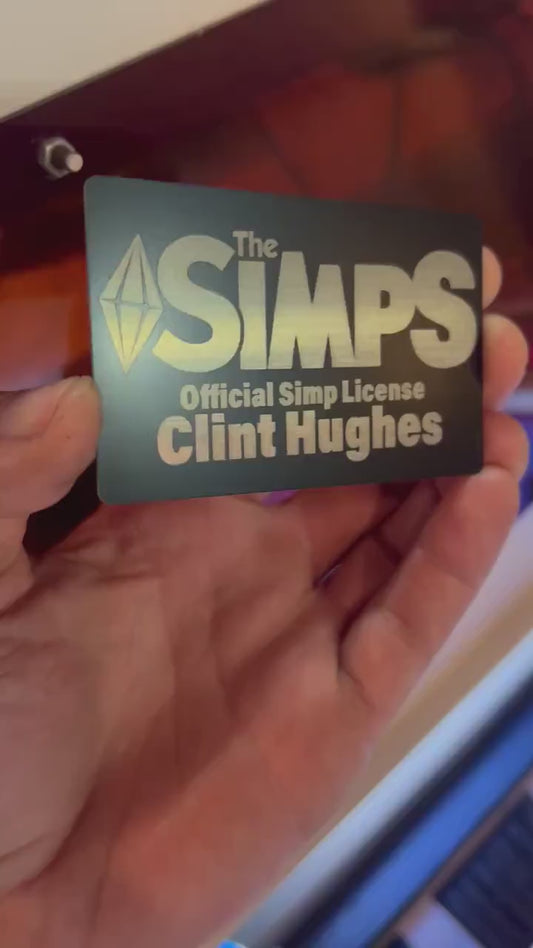 Video of hand holding a metal laser engraved gag gift with The Simps, Official Simp License and custom name engraving 
