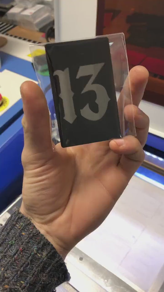 Custom anodized aluminum card being rotated to highlight the number 13 gothic typography design