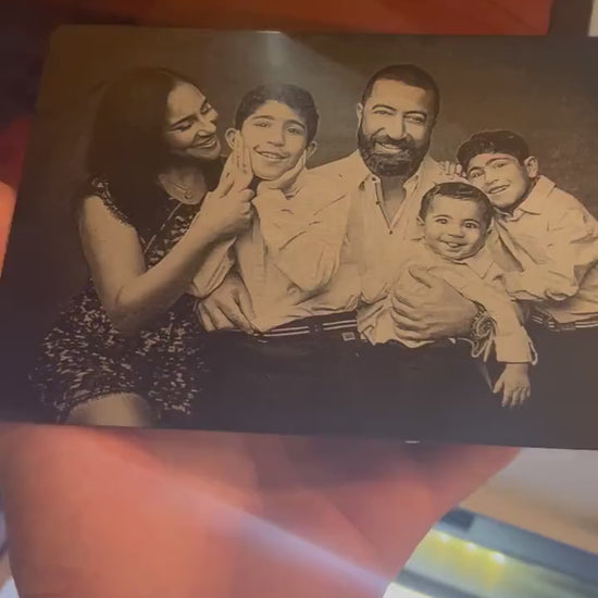 Close up video of hand holding a laser engraved metal keepsake plaque with custom artwork upload family photo portrait engraving