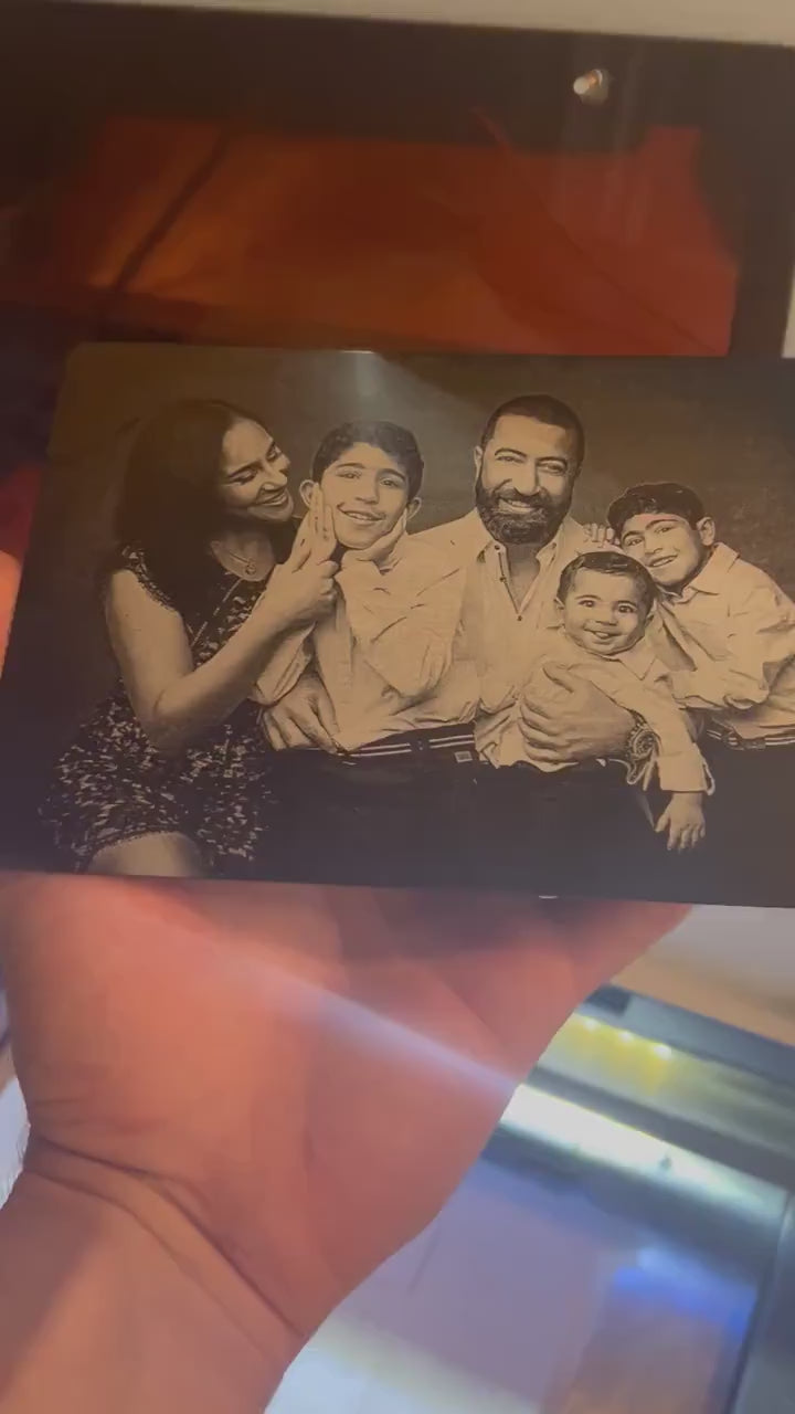 Close up video of hand holding a laser engraved metal keepsake plaque with custom artwork upload family photo portrait engraving