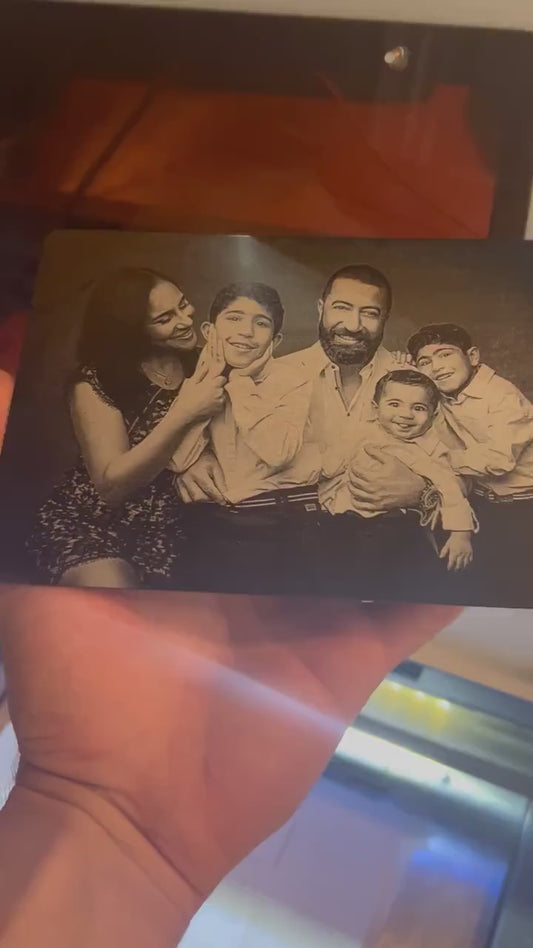 Close up video of hand holding a laser engraved metal keepsake plaque with custom artwork upload family photo portrait engraving