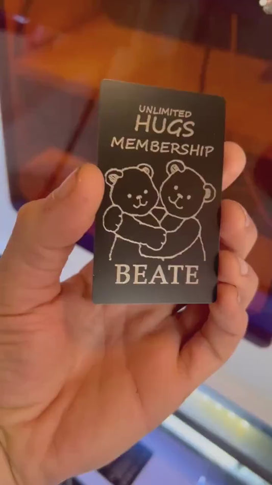 Hands rotating personalized metal Unlimited Hugs Membership card to display engraved name
