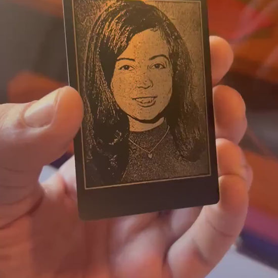 Close-up video of black anodized metal card rotating to show laser engraved custom photo portrait engraving