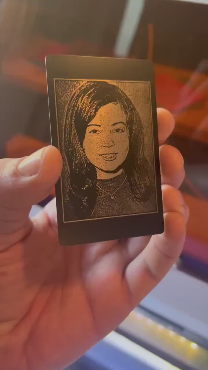 Close-up video of black anodized metal card rotating to show laser engraved custom photo portrait engraving