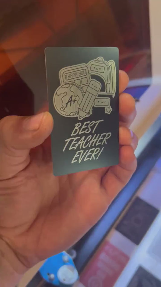 Close-up video of black anodized metal card rotating to show laser engraved best teacher ever artwork and design
