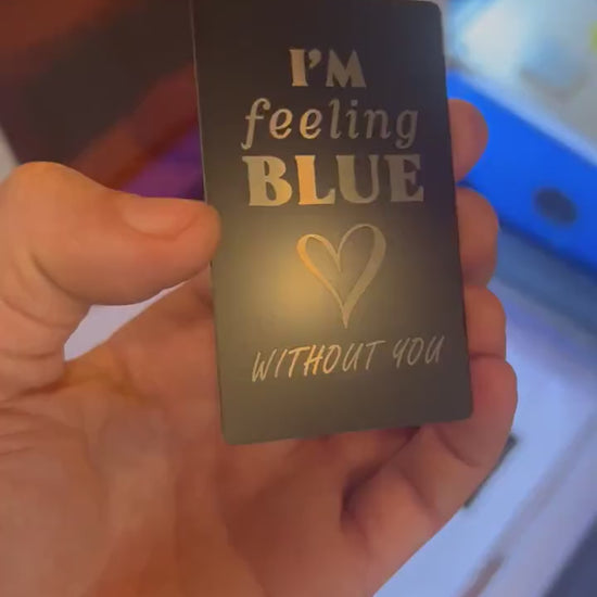 Close-up video of laser engraved metal I'm feeling blue with out you keepsake card rotating to show shine and detail