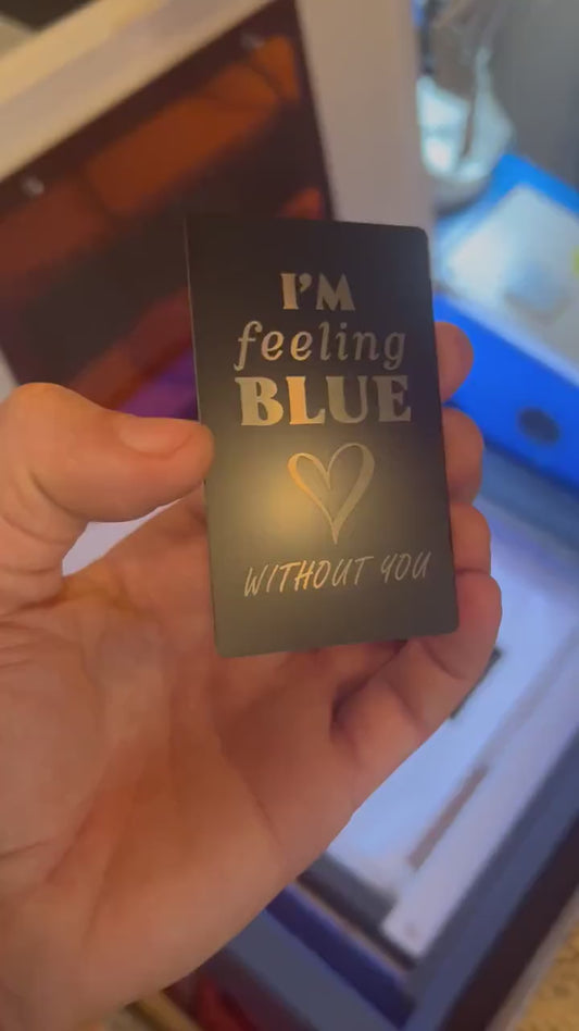 Close-up video of laser engraved metal I'm feeling blue with out you keepsake card rotating to show shine and detail