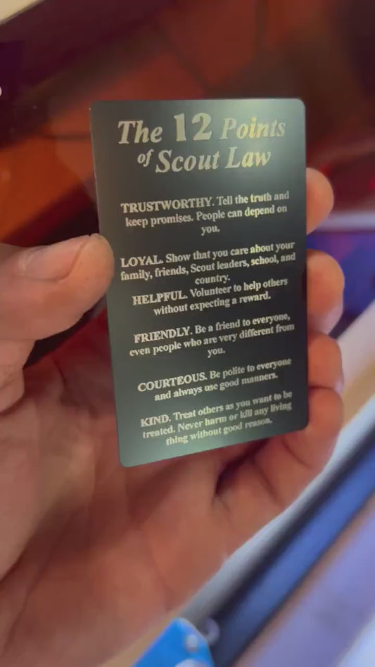 video of a hand holding and rotating a laser engraved metal 12 points of scout law 