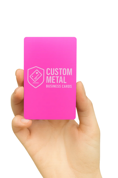 Hand holding a pink card with 'Custom Metal Business Cards' text on a white background