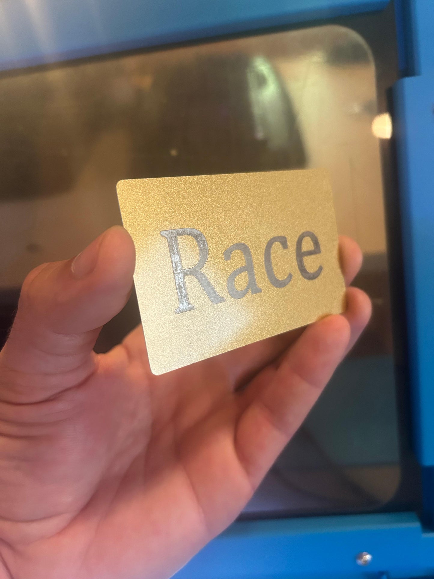 Laser engraved metal "Race Card" with the word Race engraved on an anodized aluminum card in Gold/Silver