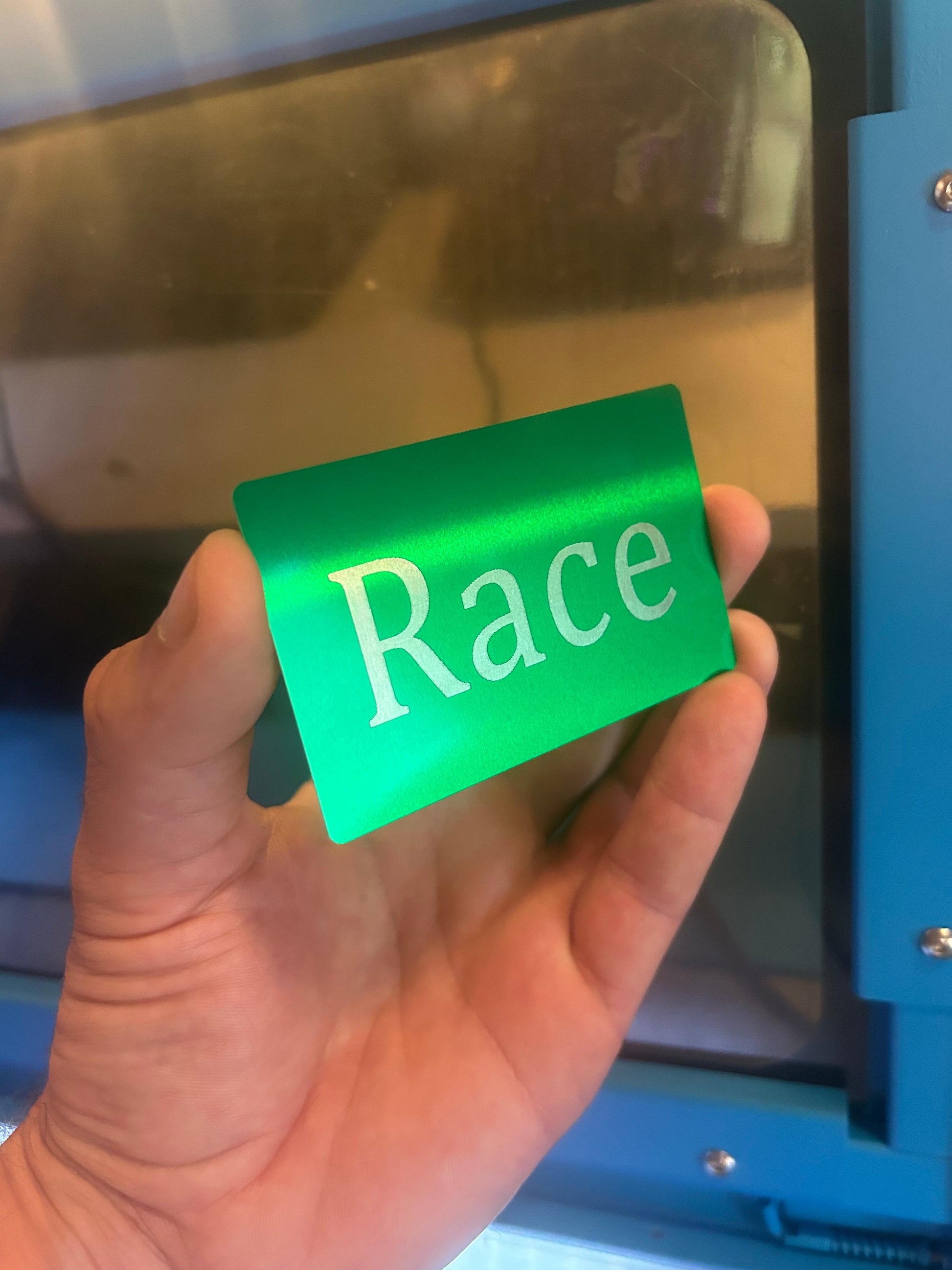 Laser engraved metal gag gift card with the word "Race" engraved on front
