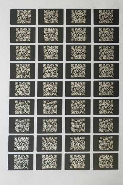 Sheet of QR code metal business cards arranged in a grid on a white background