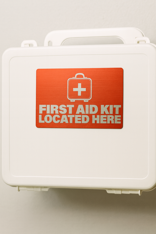 red metal card stating "first aid kit located here" shown on medical box