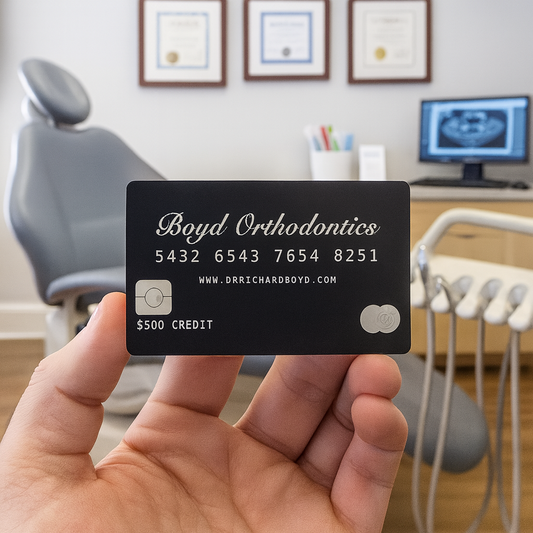Hand holding a faux metal gift card with 'Orthodontics office' coupon details in an orthodontist office setting.