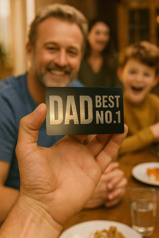 Hand holding a metal keepsake with 'DAD BEST NO.1' in front of a family at a table.