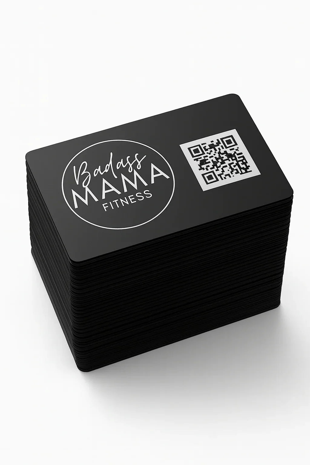 Stack of black business cards with 'Badass Mama Fitness' logo and QR code on a white background