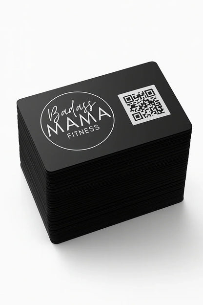 Stack of black business cards with 'Badass Mama Fitness' logo and QR code on a white background