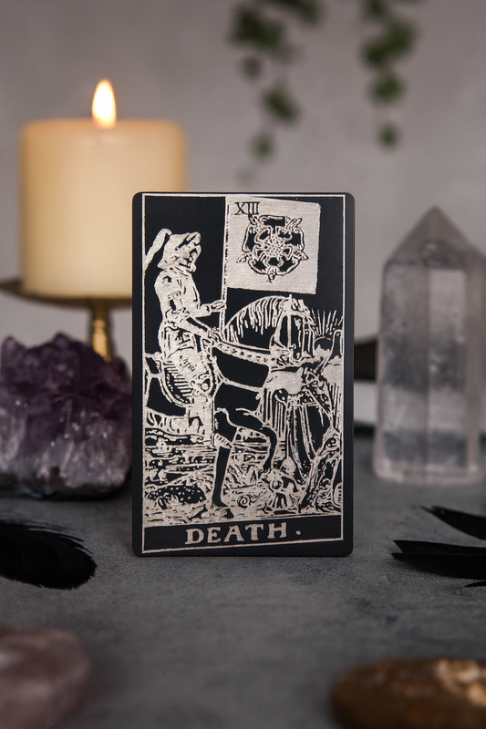 Metal black/silver Tarot card titled 'Death' with a candle and crystals in the background